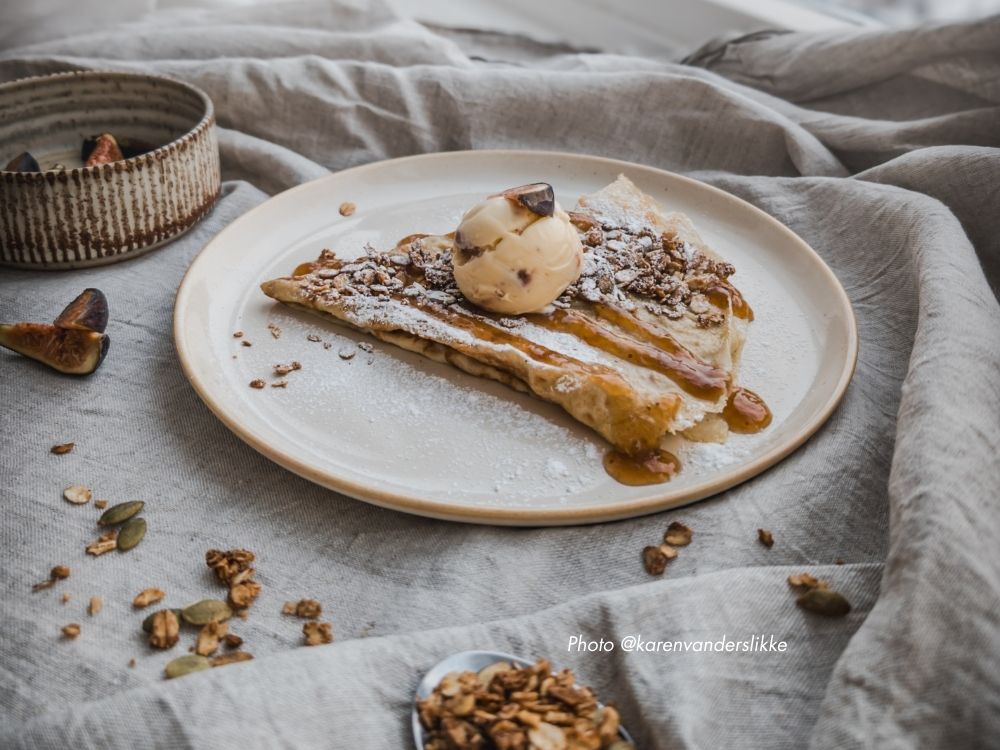 Crepe med fikonglass, havresmul och fikonsirap på en tallrik av keramik