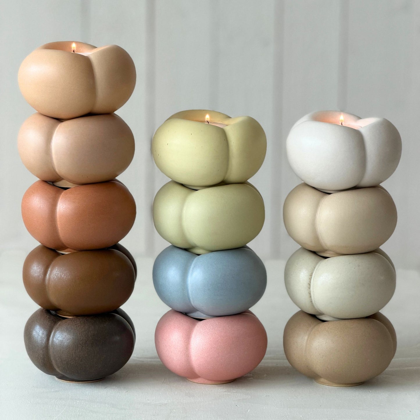 Runda ljuslyktor i keramik staplade i olika färger