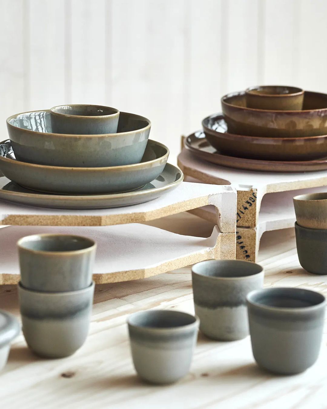 Servis i keramik med färgskiftningar, tallrikar och koppar