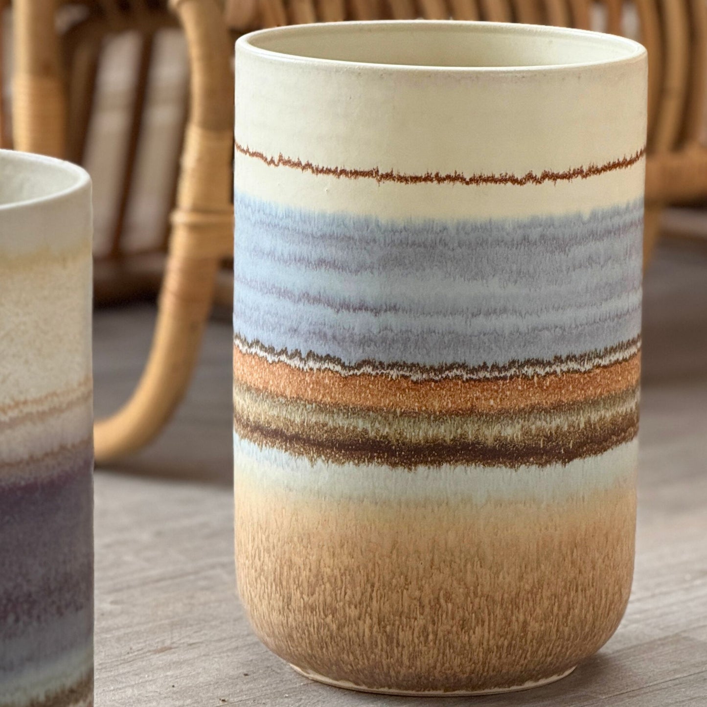 Närbild av stor keramikvas med vågräta färgskiftningar